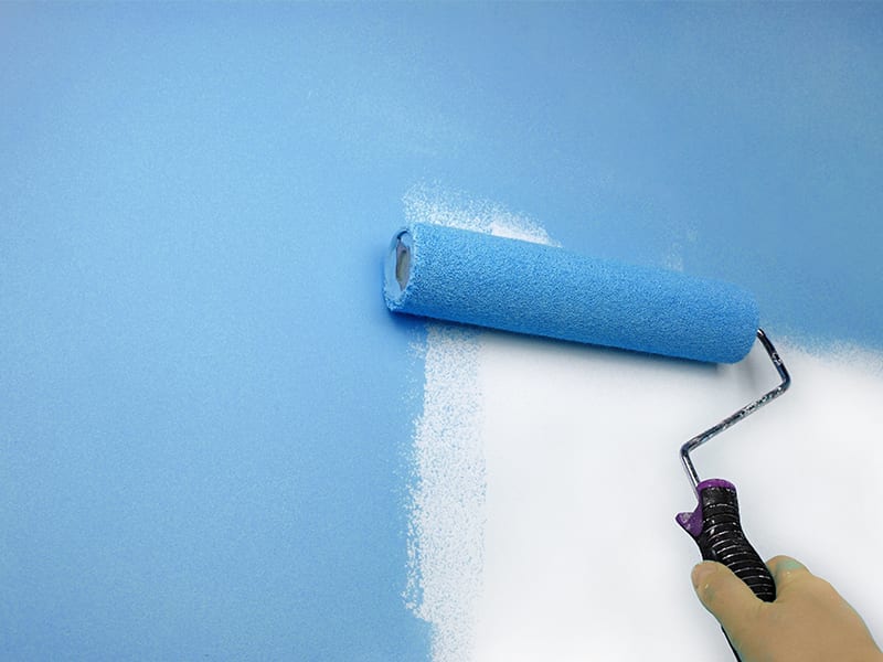 rolling blue paint on wall